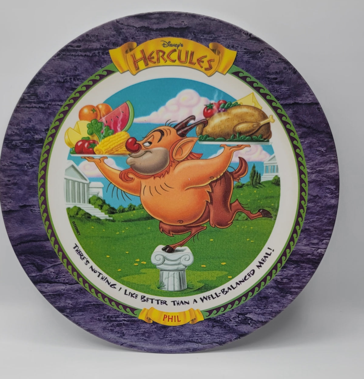 Disney's Hercules 1997 decorative plate featuring Phil as a muscular centaur carrying a feast, set against a purple marbled border with the title 'Hercules' at the top.