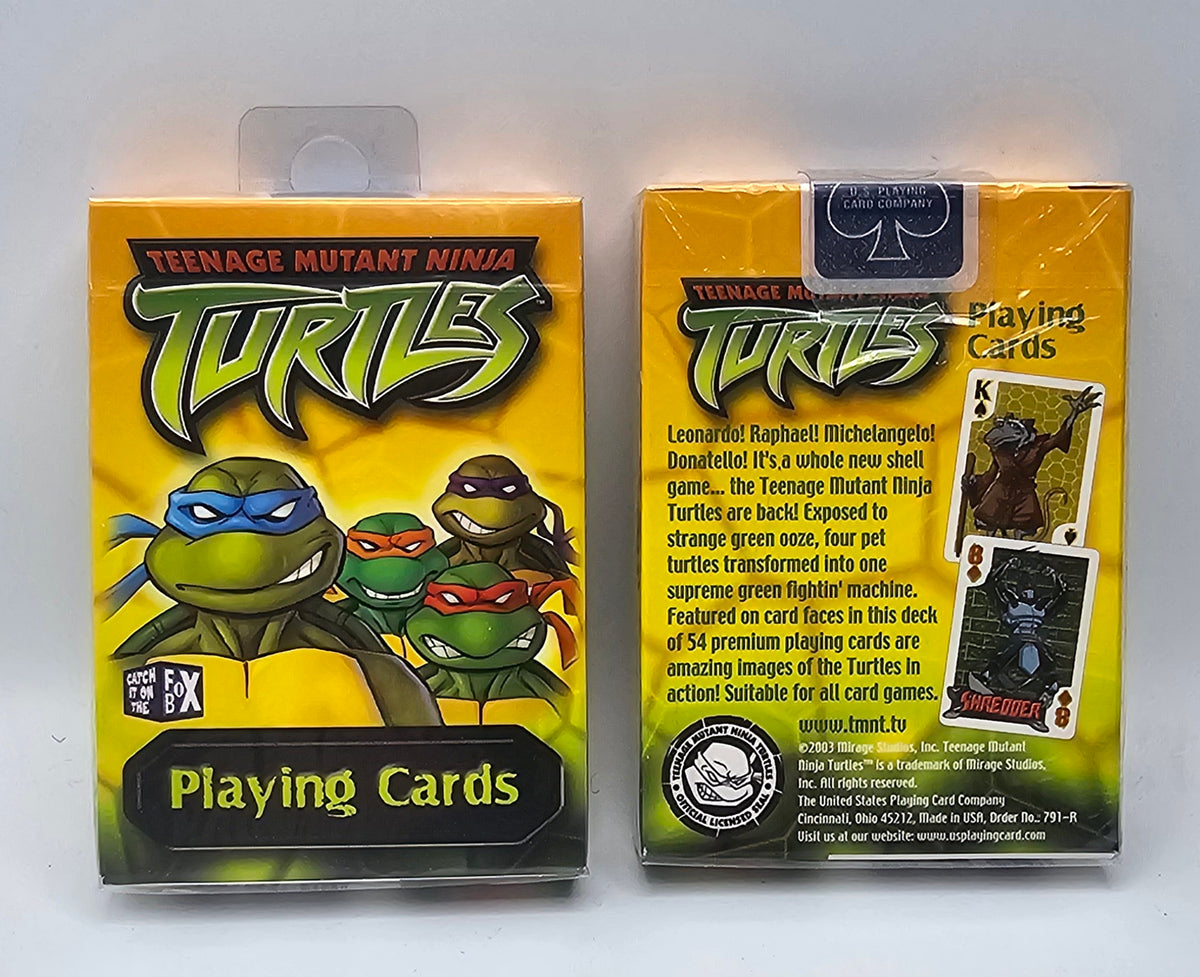 Teenage Mutant Ninja Turtles playing cards box shown front and back on a white background. The yellow packaging features the Turtles' illustrated logos and character art, with text indicating a deck of 54 premium playing cards.