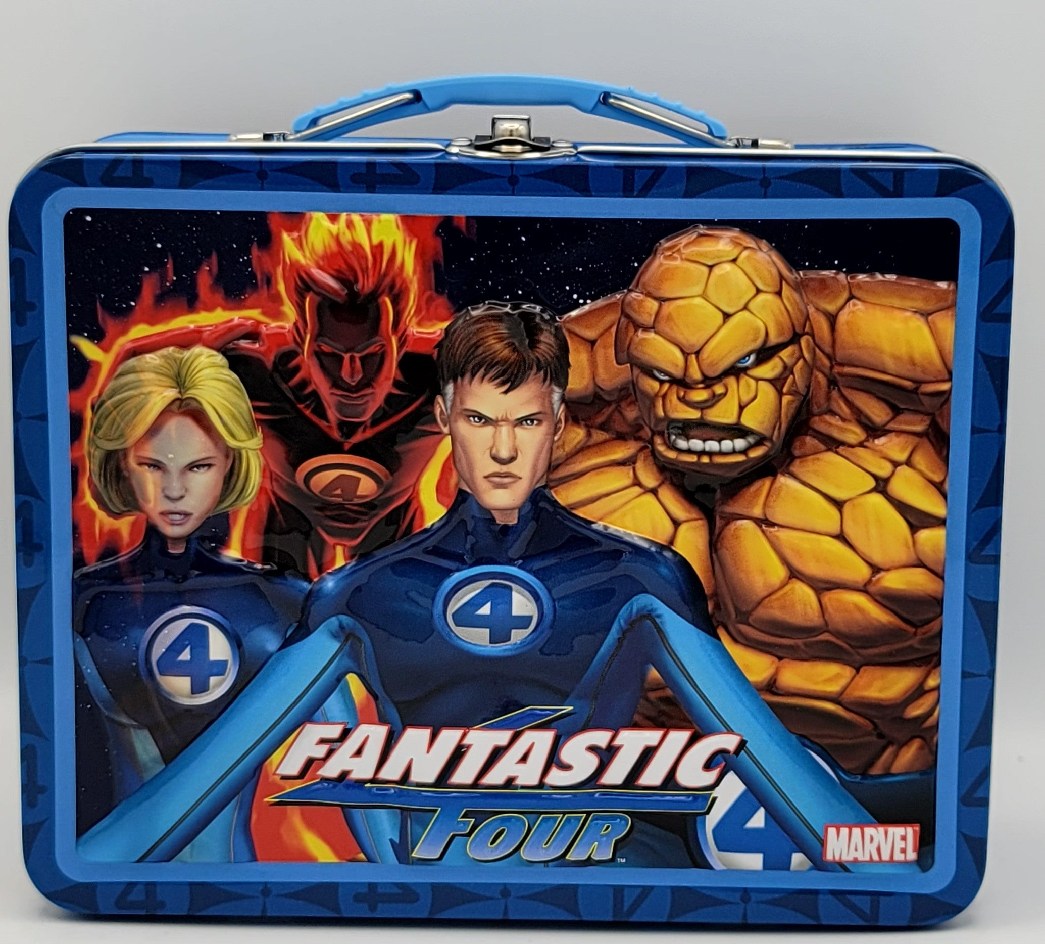 A blue metal lunch box featuring Fantastic Four characters including Invisible Woman, Invisible Man, The Thing, and Human Torch, with the text 'FANTASTIC FOUR' and a Marvel logo.