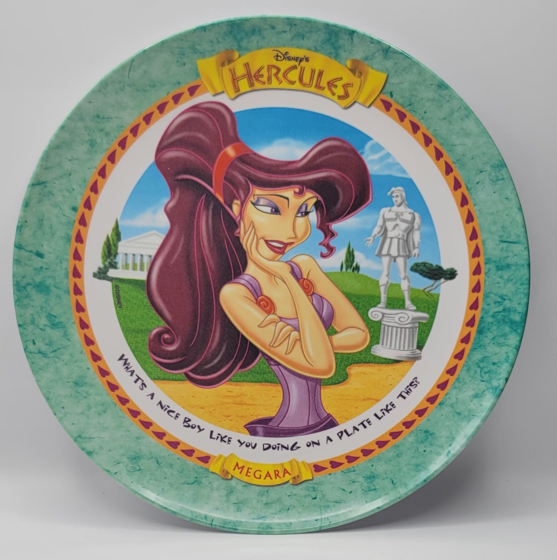 A round decorative plate featuring Disney's Hercules artwork, with Megara as the central character, set against a light gray background.