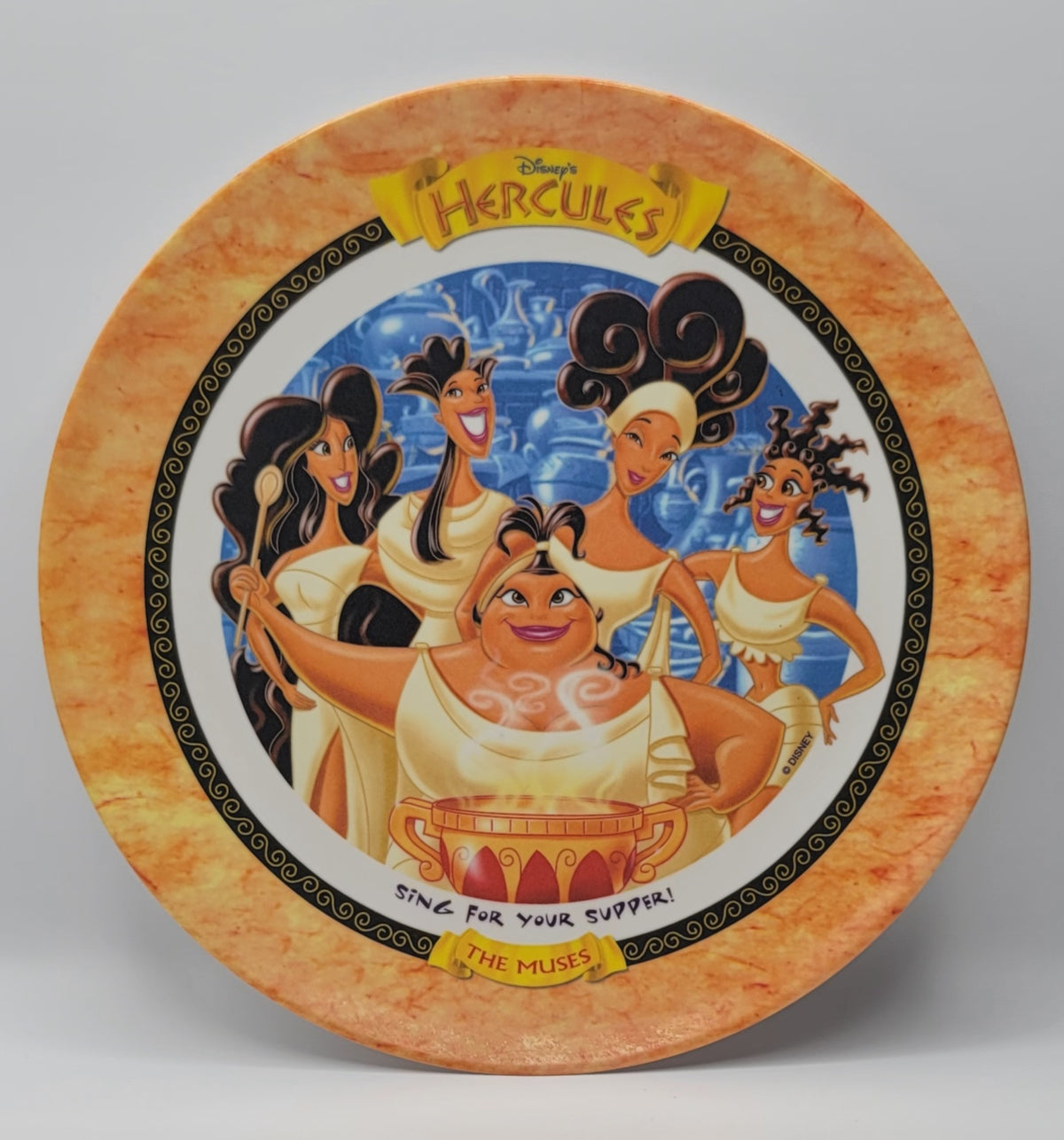 Disney Hercules collectible melamine Muses plate featuring the main characters from the film, set against a light gray background.