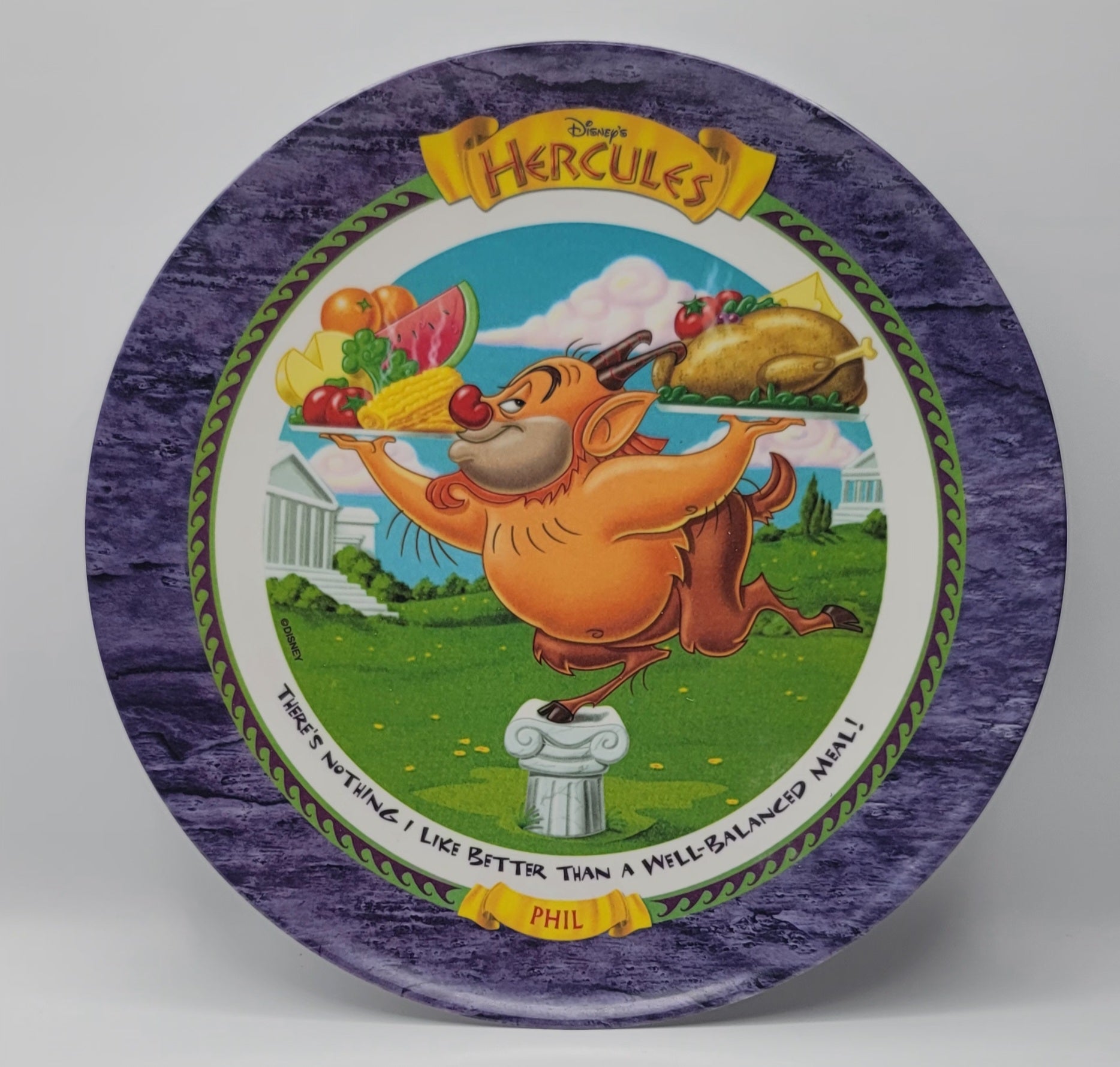 Disney Hercules collectible ceramic plate featuring the character Phil as a crow, holding a feast of fruits and a roasted turkey, with a purple marbled border and yellow Disney Hercules logo.