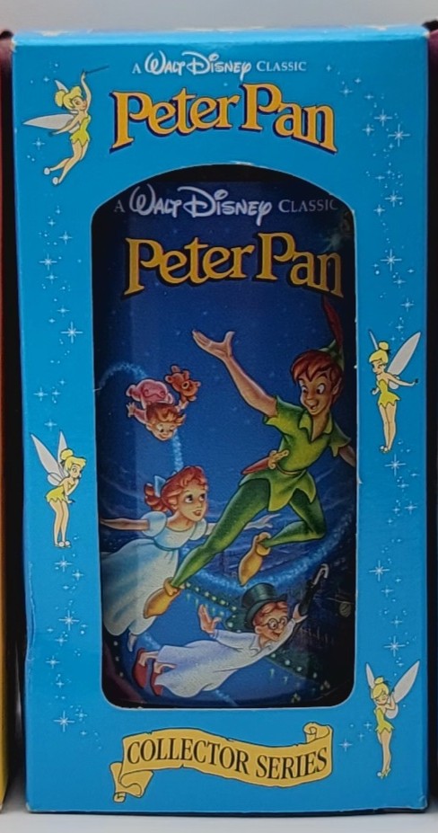 A Walt Disney Classic Peter Pan Collector Series collectible glass bottle in its original blue cardboard packaging, featuring illustrations of Peter Pan, Tinker Bell, and other characters on the front.