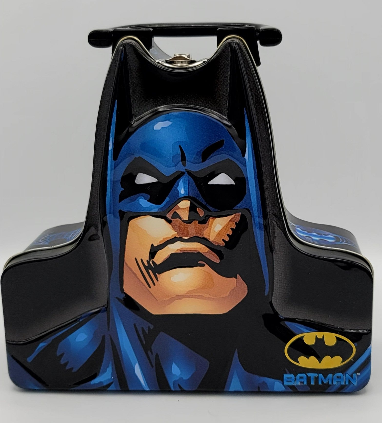 A Batman-themed hard case or container featuring a large printed illustration of Batman's face on the front, with blue and black costume graphics and a yellow Batman logo near the lower right.